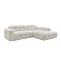 Modulares, elegantes Ecksofa mit gepolstertem Design in Hellbeige.