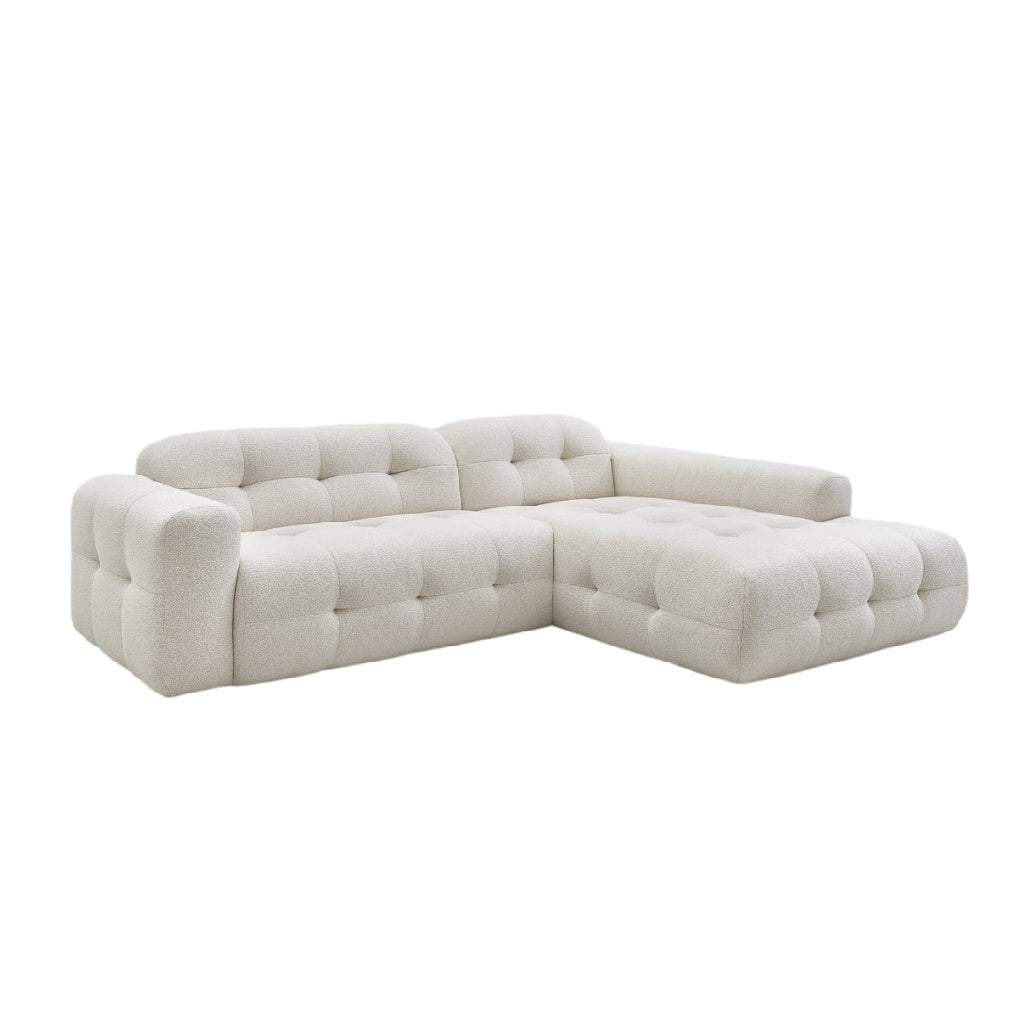 Modulares, elegantes Ecksofa mit gepolstertem Design in Hellbeige.